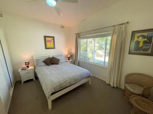 a bedroom with a bed and a large window at Elizabeth Beach Guest House in Elizabeth Beach