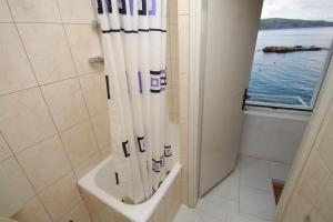 a bathroom with a shower with a view of the ocean at Apartments and rooms by the sea Komiza, Vis - 2431 in Komiža