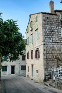 an old stone building with a tree in front of it at Studio Komiza 2429e in Komiža +4 photos
