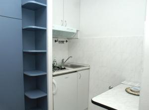 a small white kitchen with a sink and a counter at Studio Komiza 2429e in Komiža