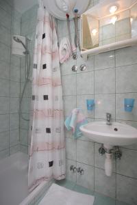 a bathroom with a sink and a shower curtain at Apartments and rooms with parking space Mali Losinj (Losinj) - 2486 in Mali Lošinj