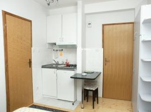 a small kitchen with a table and a door at Apartments by the sea Komiza, Vis - 2429 in Komiža +18 photos