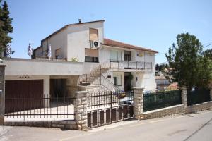 a white house with a wrought iron fence at Apartment Mali Losinj 2486a in Mali Lošinj +17 photos