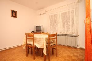 a dining room with a table and chairs at Apartment Mali Losinj 2486a in Mali Lošinj