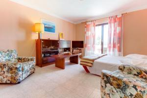 a hotel room with a bed and two chairs at Apartments by the sea Mali Losinj (Losinj) - 2489 in Mali Lošinj