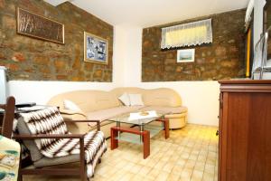 a living room with a couch and a table at Apartments by the sea Mali Losinj (Losinj) - 2493 in Mali Lošinj