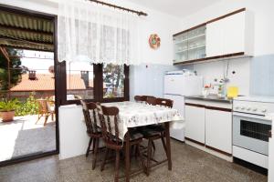 a kitchen with a table and chairs and a window at Apartments by the sea Mali Losinj (Losinj) - 2493 in Mali Lošinj