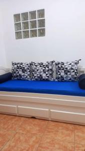 a bed with a blue cushion on a wall at Rent apartament Rio de Janeiro Copacabana in Rio de Janeiro