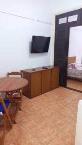 a living room with a table and a tv at Rent apartament Rio de Janeiro Copacabana in Rio de Janeiro