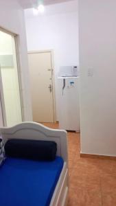 a white room with a bed and a refrigerator at Rent apartament Rio de Janeiro Copacabana in Rio de Janeiro