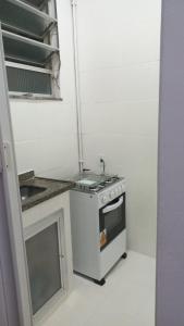 a small kitchen with a stove and a sink at Rent apartament Rio de Janeiro Copacabana in Rio de Janeiro