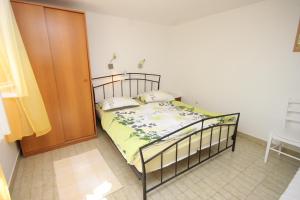 sypialnia z łóżkiem i drewnianymi drzwiami w obiekcie Apartments and rooms with parking space Mali Losinj (Losinj) - 2497 w miejscowości Mali Lošinj