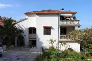 a white house with a balcony on top of it at Apartments with a parking space Mali Losinj (Losinj) - 2507 in Mali Lošinj
