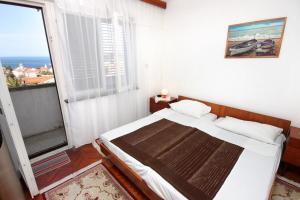 a bedroom with a bed and a large window at Apartments with a parking space Mali Losinj (Losinj) - 2507 in Mali Lošinj