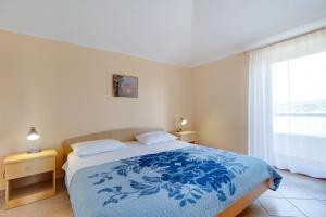 a bedroom with a bed and a large window at Apartments and rooms with parking space Nerezine, Losinj - 2506 in Nerezine