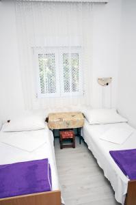 a room with two beds and a table in it at Twin Room Podaca 2613d in Podaca