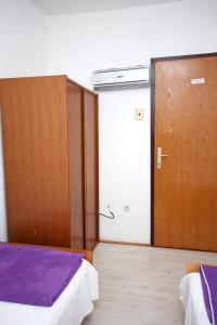a room with two beds and a wooden door at Twin Room Podaca 2613d in Podaca
