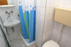 uma casa de banho com uma cortina de chuveiro ao lado de um WC em Apartment Podaca 2621a em Podaca