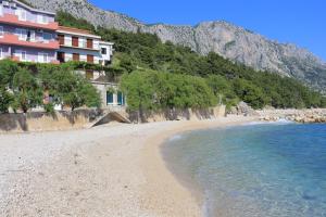 a beach in front of a hotel and the ocean at Apartments and rooms by the sea Podgora, Makarska - 2616 in Podgora