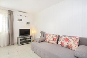 - un salon avec un canapé et une télévision dans l'établissement Apartments by the sea Podgora, Makarska - 2657, à Podgora