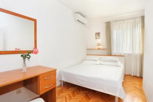 - une chambre avec un lit, un bureau et un miroir dans l'établissement Apartments by the sea Podgora, Makarska - 2657, à Podgora