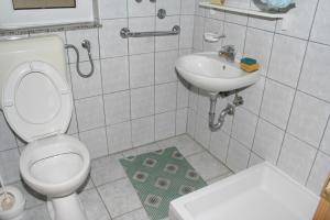 a white bathroom with a toilet and a sink at Apartments by the sea Podaca, Makarska - 2612 in Podaca