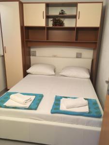 a bed in a room with two towels on it at Apartments by the sea Promajna, Makarska - 2673 in Promajna