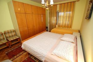 una camera con un grande letto e una finestra di Apartments and rooms by the sea Zaostrog, Makarska - 2661 a Zaostrog