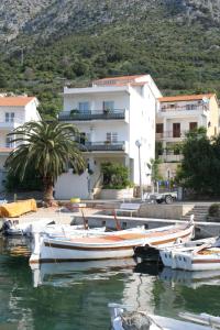 a group of boats docked in the water in front of a building at Apartments by the sea Igrane, Makarska - 2679 in Igrane