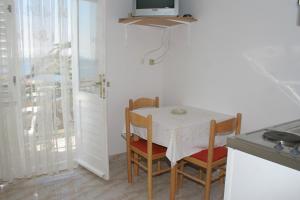 a small kitchen with a table with chairs and a television at Apartments by the sea Igrane, Makarska - 2679 in Igrane