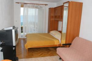 een slaapkamer met een stapelbed en een televisie bij Apartments by the sea Igrane, Makarska - 2679 in Igrane