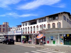 een wit gebouw in een stadsstraat met winkels bij Residencial Casabella in Florianópolis