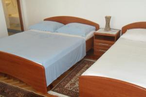 a bedroom with two twin beds and a night stand at Apartments and rooms by the sea Zaostrog, Makarska - 2662 in Zaostrog