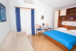 a bedroom with a bed and a table and a couch at Apartments by the sea Promajna, Makarska - 2605 in Promajna