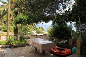 a table and chairs and a boat on a patio at Apartments by the sea Zivogosce - Mala Duba, Makarska - 2603 in Igrane