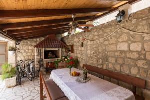 a dining room with a table and a stone wall at Apartments and rooms by the sea Slano, Dubrovnik - 2687 in Slano