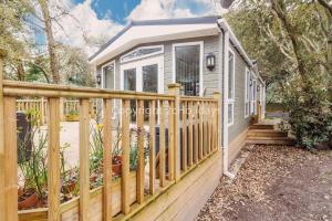 une petite maison avec une clôture en bois et des escaliers dans l'établissement Pet Friendly, Luxury Caravan For Hire In Suffolk By The Beach Ref 32203og, à Lowestoft
