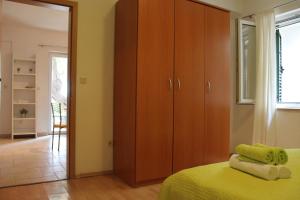 a bedroom with a closet and a bed with yellow sheets at Apartment Zaostrog 2625a in Zaostrog