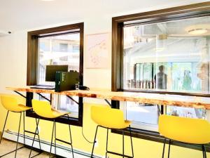 a bar in a restaurant with yellow chairs and a window at Banff International Hostel in Banff