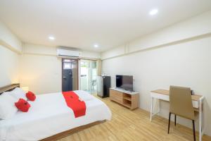 a bedroom with a bed and a desk and a television at Hoenhao Boutique Ratchada in Bang Su