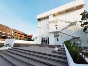 a white building with stairs in front of it at Kotta Hotel Semarang in Semarang