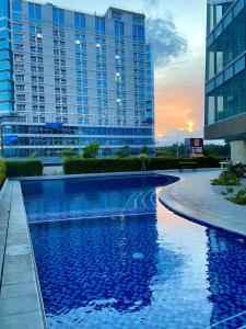 a swimming pool in front of a large building at Aeon Towers Executive Suite 2BR 18th floor in Davao City