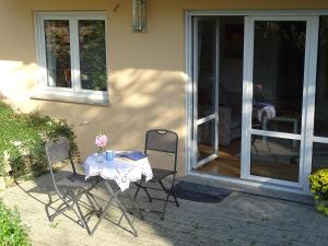einen Tisch und zwei Stühle vor einem Haus in der Unterkunft Ferienwohnung Findus in Haldenwang