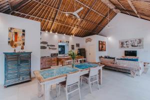 comedor con mesa, sillas y sofá en Villa Escape, en Nusa Lembongan