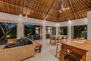 an open living room with a table and chairs at Villa Escape in Nusa Lembongan