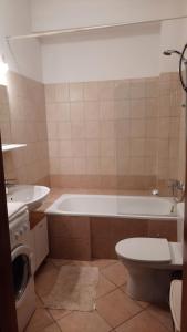 a bathroom with a tub and a toilet and a sink at Pelican - Czarny Dwór A in Zaspa +9 photos