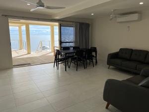 ein Wohnzimmer mit einem Tisch, Stühlen und einem Sofa in der Unterkunft Beachside & Jetty View Apartment 2 -Skippers Apartment in Streaky Bay