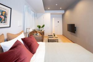 a bedroom with a bed and a living room at Ken's Place麻布East in Tokyo