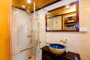 y baño con lavabo y ducha. en Victory Cruise en Ha Long