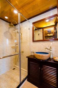 y baño con lavabo y ducha acristalada. en Victory Cruise en Ha Long